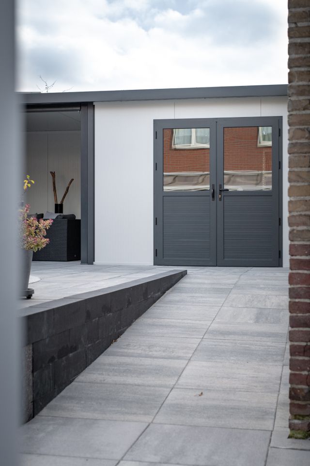 Overkapping of veranda met tuinschuur met dubbele deuren.